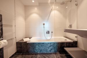 a bathroom with a tub with a glass shower at Chalet with a beautiful view on the heights of in Verbier