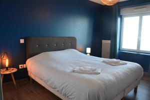a blue bedroom with a bed with two towels on it at Digue in Wimereux