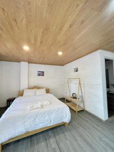 a bedroom with a large bed with a wooden ceiling at Scent Village Hotel in Da Lat