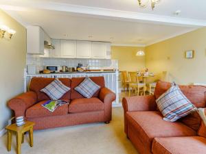 a living room with two couches and a kitchen at 1 Bed in Tenby 83320 in Tenby