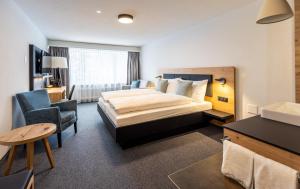A bed or beds in a room at Hotel Piz Badus