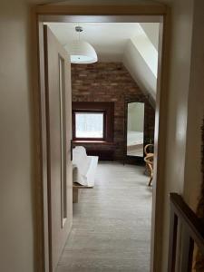 a hallway with a room with a brick wall at Mednieku Namiņš in Sigulda