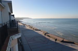 a group of people walking along the beach at Digue in Wimereux