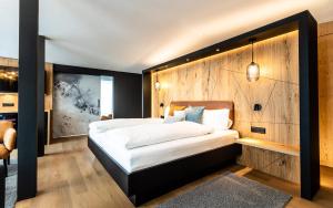 um quarto com uma cama grande e uma parede de madeira em Hotel Piz Badus em Andermatt