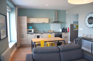a kitchen and dining room with a table and yellow chairs at Digue in Wimereux