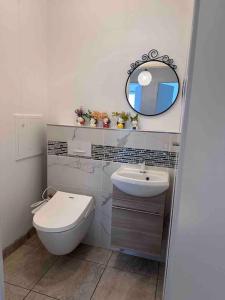a bathroom with a toilet and a sink and a mirror at Appartement adorable et jardin in Villiers-sur-Marne