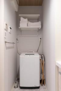 uma lavandaria com máquina de lavar e secar roupa em 松山大街道HOTELさくら- unmanned hotel - em Matsuyama