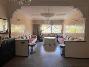 una gran sala de estar con sofás y una mesa. en Beautiful 2-Bed Apartment in Rabat Hay Riad, en Kouas