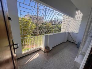 a balcony with a large window and a plant at Beautiful 2-Bed Apartment in Rabat Hay Riad in Kouas