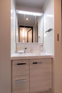 bagno con lavandino e specchio di 松山大街道HOTELさくら- unmanned hotel - a Matsuyama