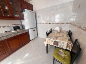 a small kitchen with a table and a refrigerator at Beautiful 2-Bed Apartment in Rabat Hay Riad in Kouas