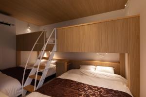 松山大街道HOTELさくら- unmanned hotel - في ماتسوياما: غرفة نوم مع سرير بطابقين مع سلم