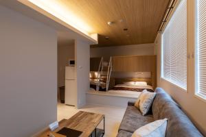 松山大街道HOTELさくら- unmanned hotel - في ماتسوياما: غرفة معيشة مع أريكة وسرير
