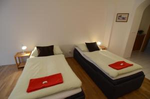 two beds in a room with red towels on them at Apartments Karlin in Prague