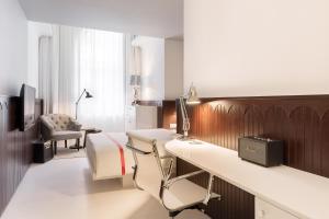 une chambre d'hôpital avec un bureau et une chaise dans l'établissement Ruby Hanna Hotel Stuttgart, à Stuttgart