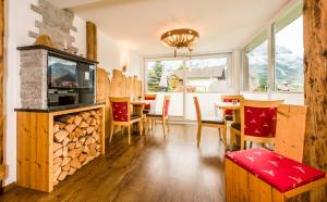 ein Wohnzimmer mit einem Kamin, einem Tisch und Stühlen in der Unterkunft Appartementhotel Zugspitzhof in Ehrwald