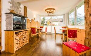 sala de estar con chimenea, mesa y sillas en Appartementhotel Zugspitzhof en Ehrwald