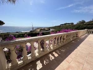 a fence with purple flowers on it with the ocean at Villa Les Issambres, 4 pièces, 7 personnes - FR-1-632-4 in Les Issambres