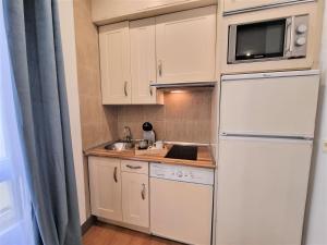 a white kitchen with a sink and a refrigerator at MOLINA - LA LATINA in Madrid