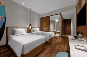 a hotel room with two beds and a bathroom at Holiday Inn Resort Bali Canggu by IHG in Canggu
