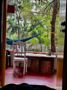 una mesa y una silla frente a una ventana en Endless Blue Hostel, 