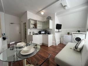 a living room with a glass table and a kitchen at Modern cosy studio in Barbican - Green - F2 in London