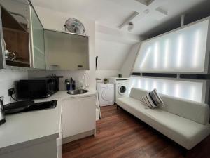 a kitchen with a couch and a sink in a room at Modern cosy studio in Barbican - Green - F2 in London