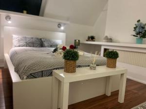 a bedroom with a bed with two plants on a table at Modern cosy studio in Barbican - Green - F2 in London