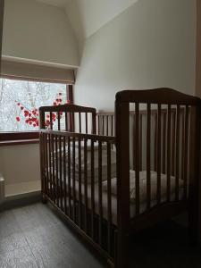 a crib in a room with a window at Mednieku Namiņ&scaron; in Sigulda