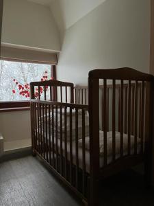 a crib in a room with a window at Mednieku Namiņš in Sigulda