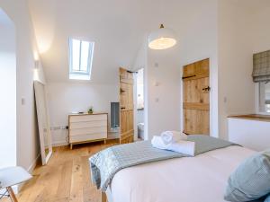 1 dormitorio con 1 cama blanca grande y suelo de madera en 2 Bed in Aberdovey 75026, en Llwyngwril