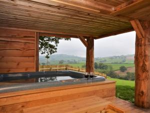 a hot tub in a wooden house with a window at 1 Bed in Bickleigh 53296 in Cadeleigh