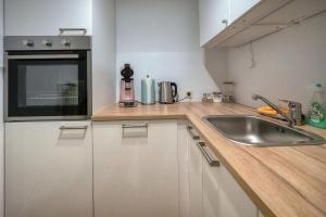 eine Küche mit einer Spüle und einer Arbeitsplatte in der Unterkunft Zentrale Ferienwohnung ROSEA nahe Kurpark in Bad Reichenhall