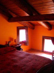 1 dormitorio con 1 cama y 2 ventanas en Il Girasole, en Mombaruzzo