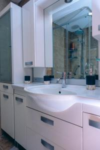 a white bathroom with a sink and a mirror at Central & Cosy Flat near Aegean Sea Bostanlı Cemal Gürsel in Karşıyaka