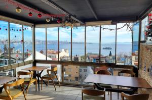 イスタンブールにあるマルマラ ゲストハウスのテーブルと椅子が備わるレストランで、水辺の景色を望めます。