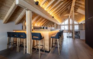 a kitchen with a wooden bar with blue stools at Hotel Piz Badus in Andermatt
