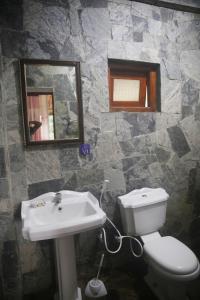 uma casa de banho com um lavatório, um WC e um espelho. em The Dream Inn em Ella