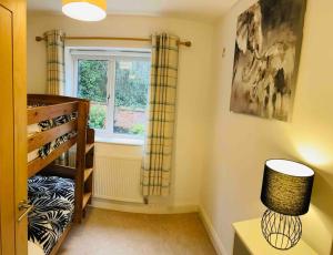 a room with a window and a table with a lamp at Balcony views + Parking in Lincolnshire