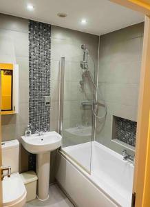 a bathroom with a shower and a sink and a toilet at Balcony views + Parking in Lincolnshire