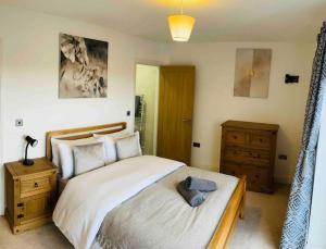 a bedroom with a large bed with a wooden headboard at Balcony views + Parking in Lincolnshire