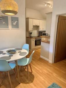 cocina con mesa y sillas en una habitación en Grooms cottage, a tranquil Cornish retreat en Lanteglos