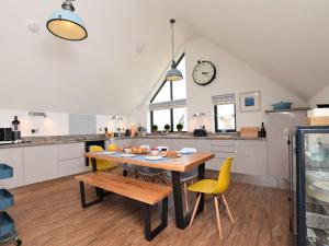 eine Küche mit einem Holztisch und gelben Stühlen in der Unterkunft 4 Bed in Westward Ho 75358 in Northam