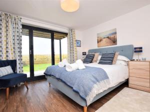 a bedroom with a bed and a large window at 4 Bed in Westward Ho 75358 in Northam