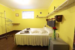 Habitación amarilla con cama con 2 almohadas en Lo studio di Podere Bellavista, en Monteprandone