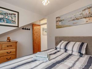 a bedroom with a bed and a wooden dresser at 3 bed property in Brixham BX017 in Brixham