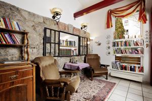 a room with chairs and a table and bookshelves at Pension Zuser in Mitterbach