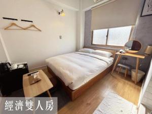 台南市にあるLittlesayの大きなベッドとテーブルのある寝室