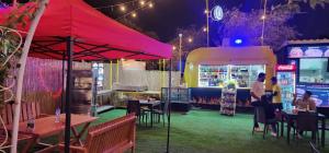 a group of people sitting at tables at a restaurant at night at Al Qudra Lakes Camping by Hyba in Dubai