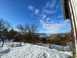 錫伯根尼的住宿－Szegfű33 Vendégház，一座雪覆盖的山丘,享有湖景